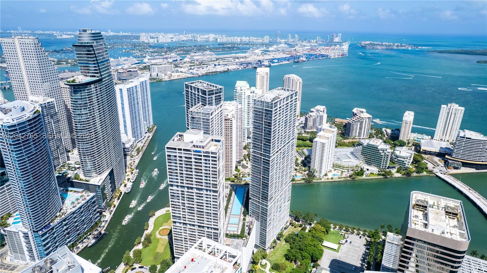 An aerial view shows high-rise apartment buildings along a canal leading to the ocean — 495 Brickell Ave # 4609, Miami FL 33131, MIAMI, FL