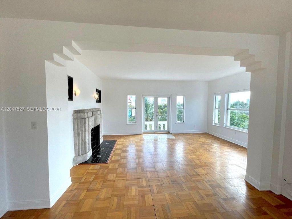 A living room features a stone fireplace, parquet wood flooring, and glass double doors — 4035 N Meridian Ave PH, Miami Beach FL 33140, MIAMI BEACH, FL