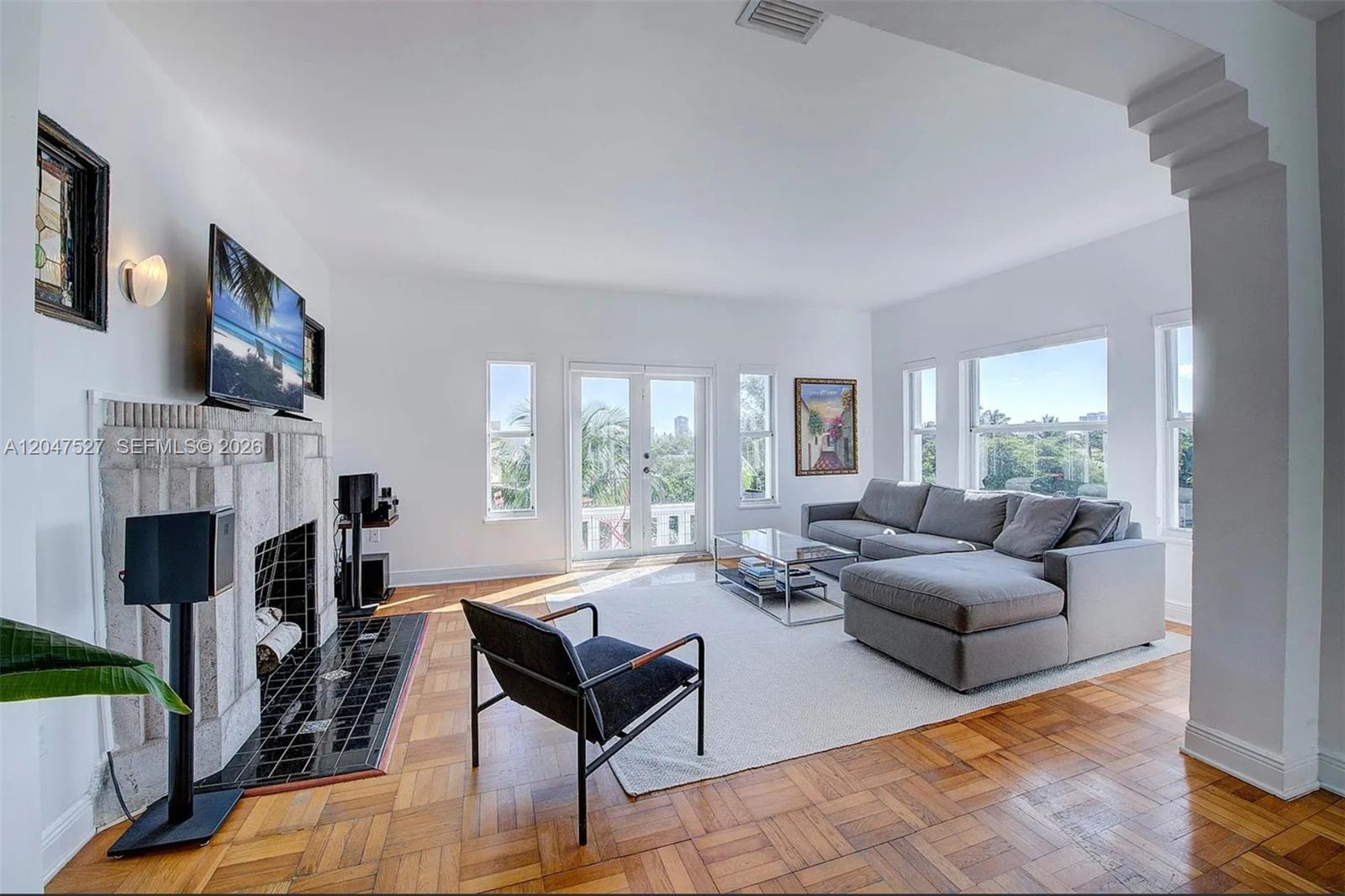 A living room features a fireplace, a gray sectional sofa, and parquet wood flooring — 4035 N Meridian Ave PH, Miami Beach FL 33140, MIAMI BEACH, FL