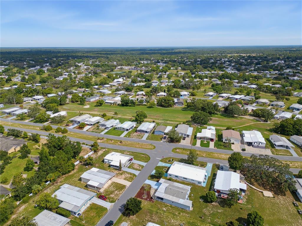 A light blue house features a covered front porch enclosed by a white picket fence — 12305 CONDE DRIVE, BROOKSVILLE, FL