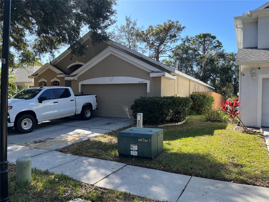 A tan single-story house with a two-car garage and a white pickup truck parked outside — 18124 ANTIETAM COURT, TAMPA, FL