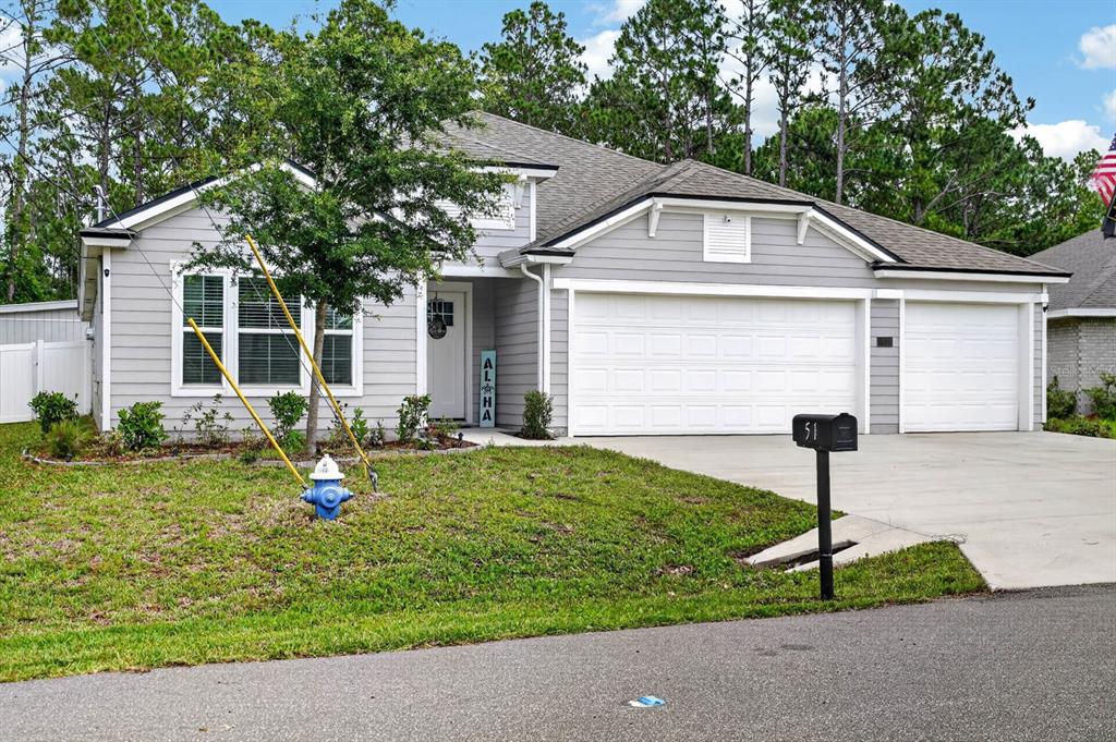 A single-story gray house with a two-car garage and a blue fire hydrant in front — 51 SENTINEL TRAIL, PALM COAST, FL