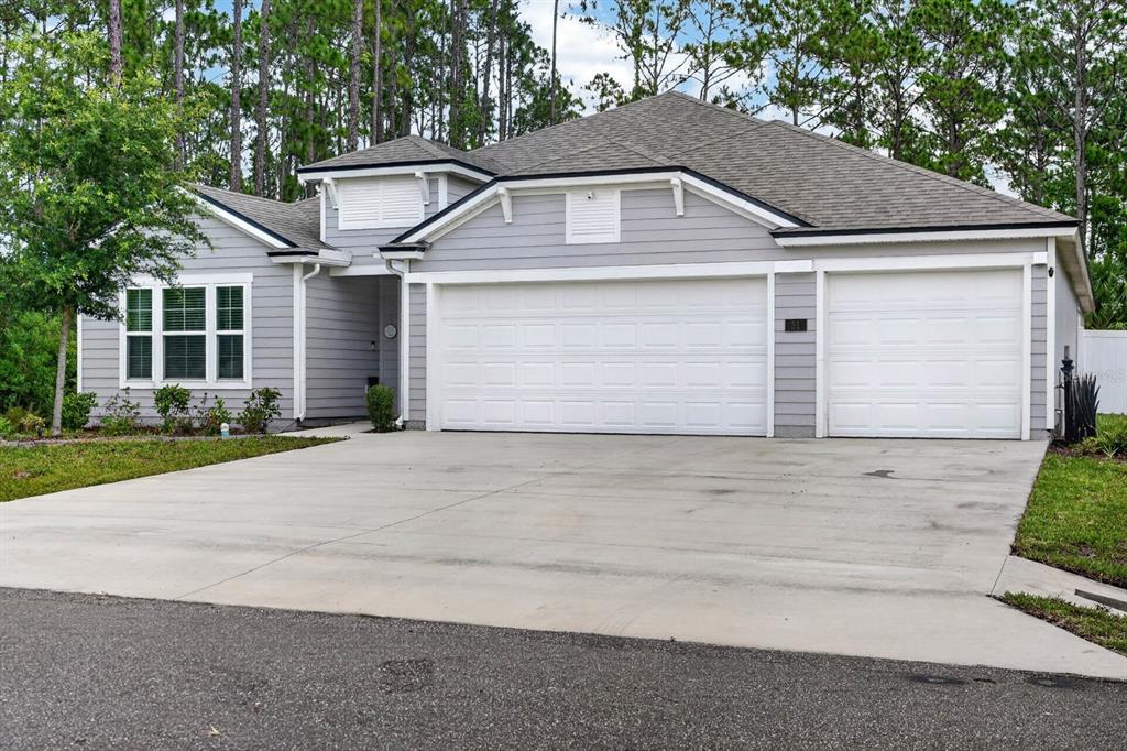 A gray, single-story house with a three-car garage and a concrete driveway — 51 SENTINEL TRAIL, PALM COAST, FL