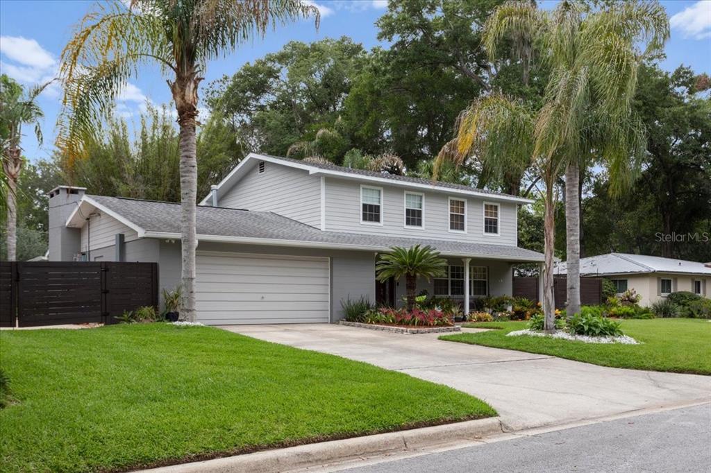 A two-story gray house with a two-car garage, palm trees, and a manicured lawn — 1940 NW 35TH STREET, GAINESVILLE, FL