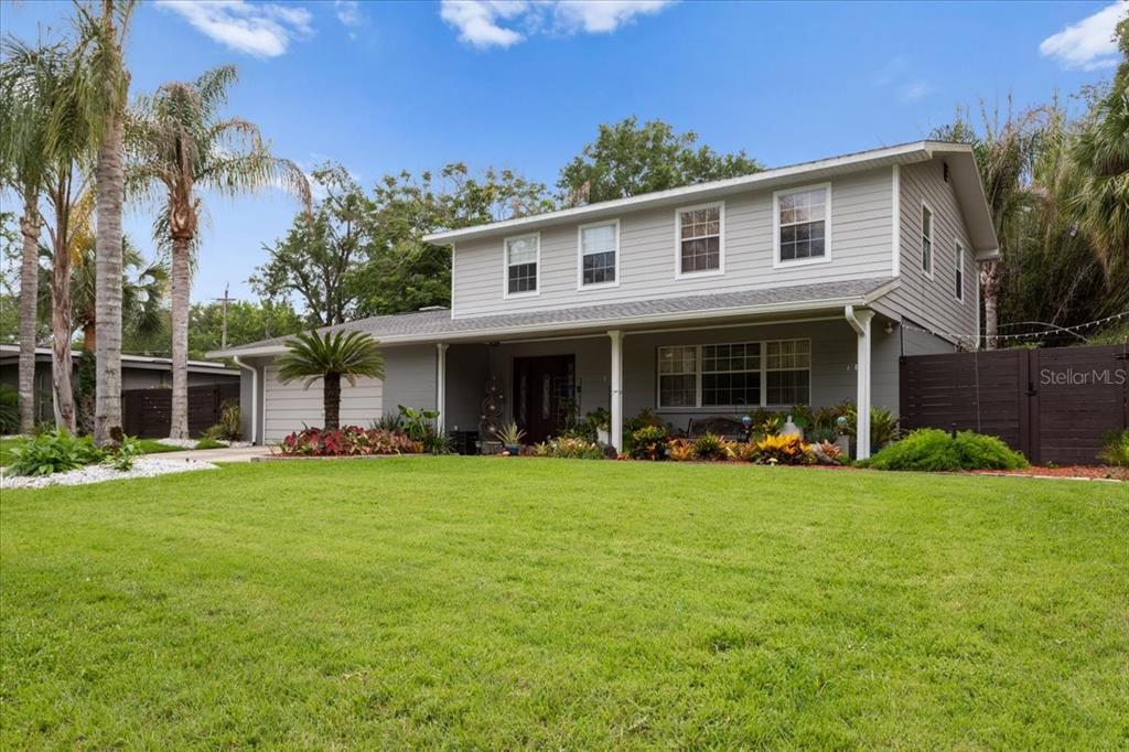 A two-story gray house with a front porch, palm trees, and a green lawn — 1940 NW 35TH STREET, GAINESVILLE, FL