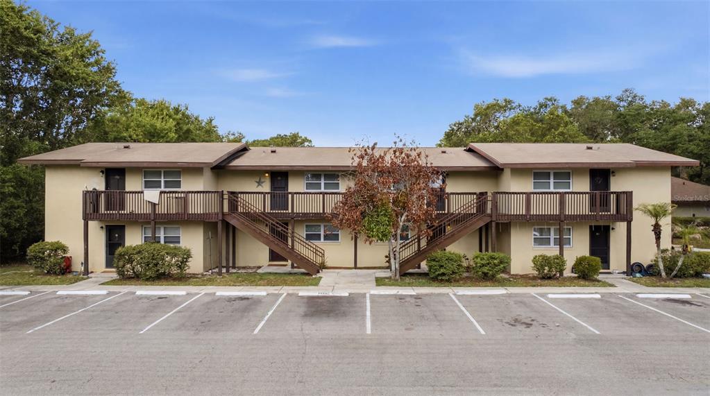 A two-story apartment building with a wooden balcony, exterior staircases, and a paved parking lot — 141 FERNERY ROAD UNIT A3, LAKELAND, FL