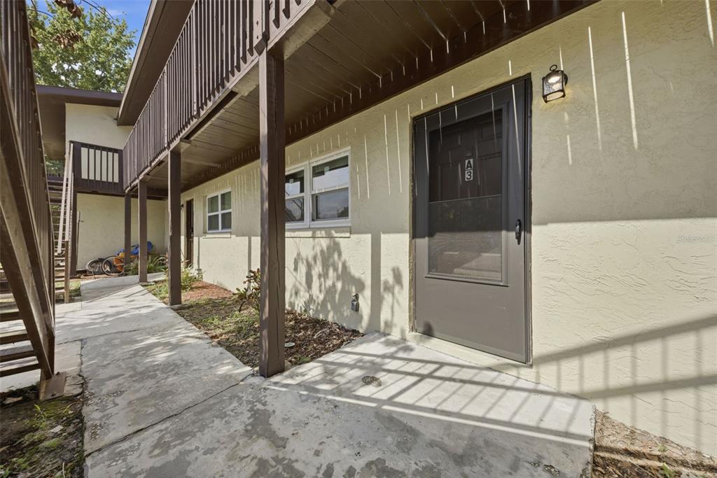 An exterior view of a ground-level apartment entrance with a screen door labeled A3 — 141 FERNERY ROAD UNIT A3, LAKELAND, FL