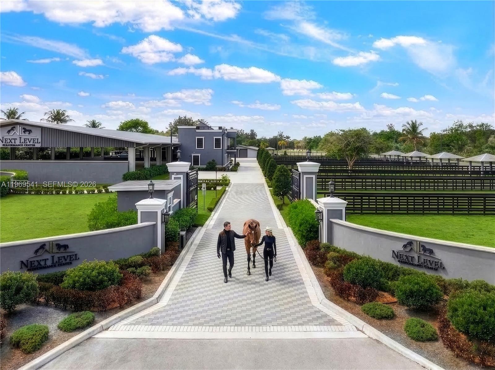 An aerial view shows a man and woman walking a horse down a paved driveway — 2625 SW 148th Ave, Davie FL 33331, DAVIE, FL