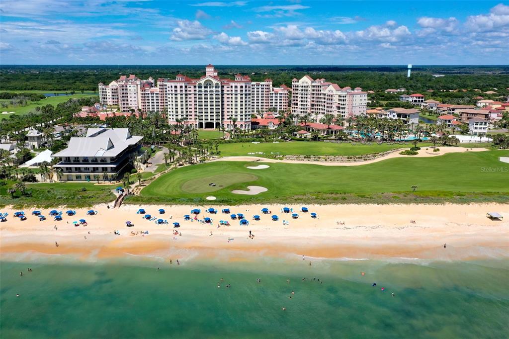 An aerial view shows a large resort hotel situated behind a golf course and beach — 200 OCEAN CREST DRIVE UNIT 108, PALM COAST, FL