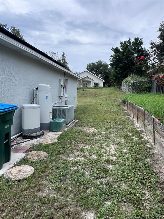 The side yard of a house features a water softener system and an air conditioning unit — 632 N GOODRICH DRIVE, DELTONA, FL