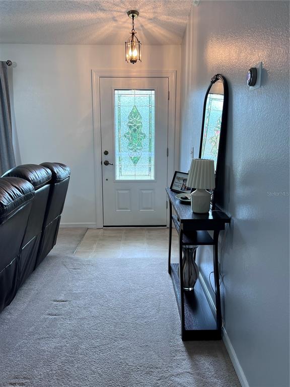 An entryway features a white front door with a decorative glass insert and a console table — 632 N GOODRICH DRIVE, DELTONA, FL