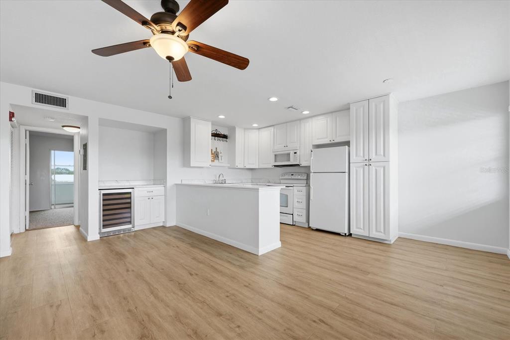 A kitchen with white cabinets, stainless steel appliances, and light wood-look flooring — 1001 77TH AVENUE N UNIT 307, ST PETERSBURG, FL