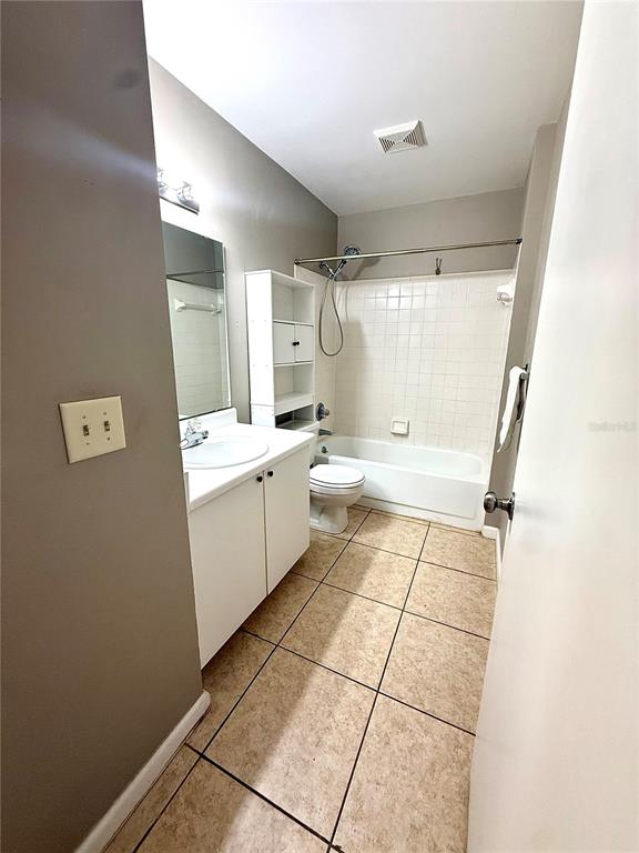 A bathroom features a white vanity, a toilet, and a tiled shower-tub combination — 242 WINTER RIDGE BOULEVARD UNIT 242, WINTER HAVEN, FL