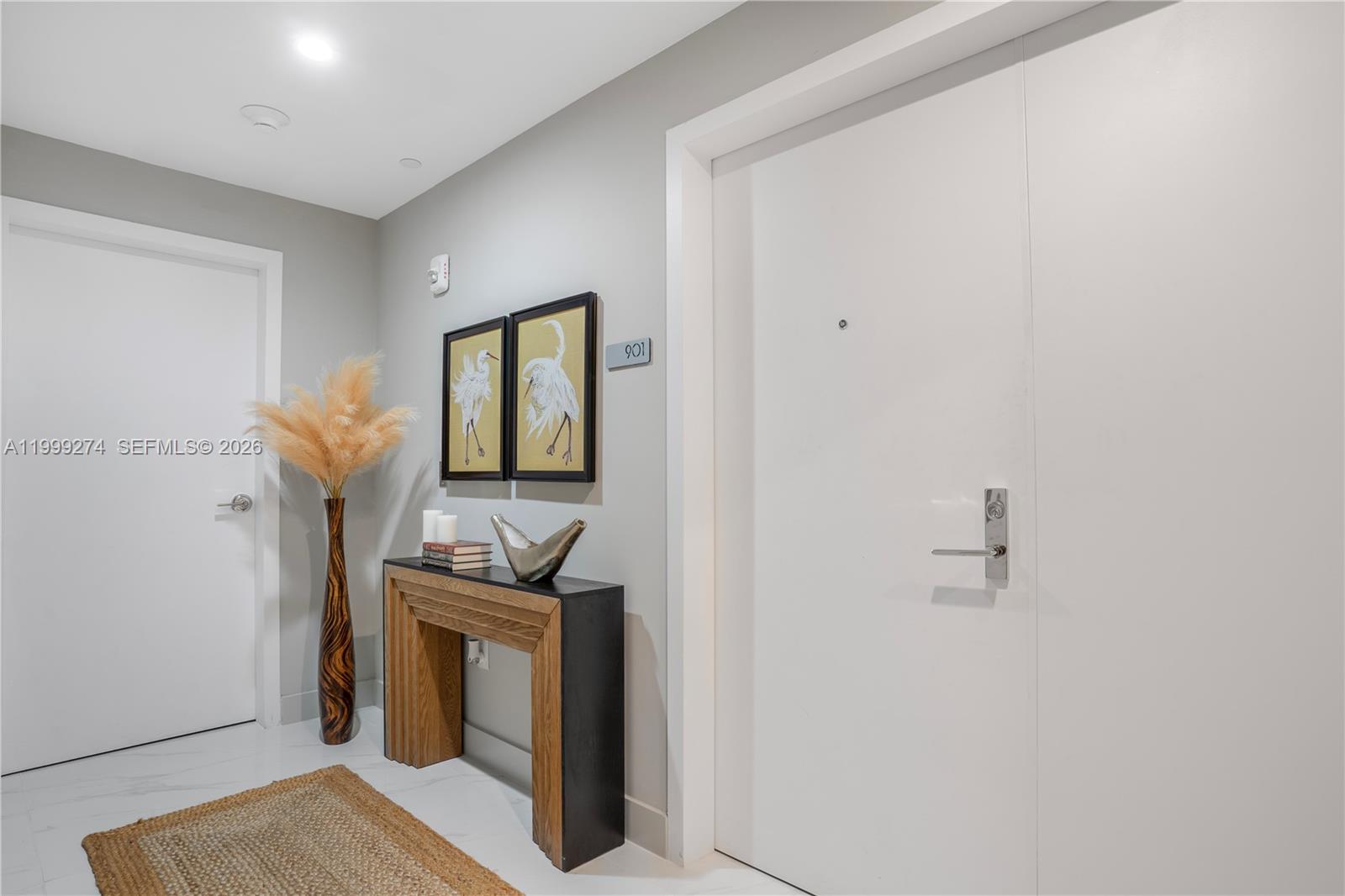 A modern entryway features a console table, two bird prints, and a white door — 700 NE 24 # 901, Miami FL 33137, MIAMI, FL