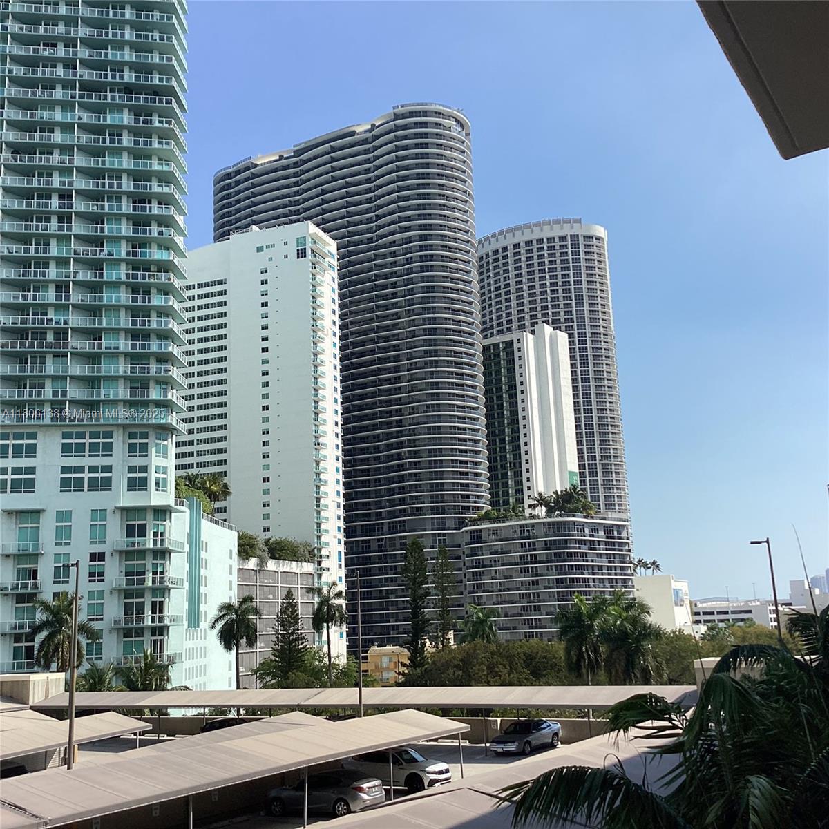 A view of several high-rise apartment buildings overlooking a parking lot with covered spaces — 2001 Biscayne Blvd # 3503, Miami FL 33137, MIAMI, FL
