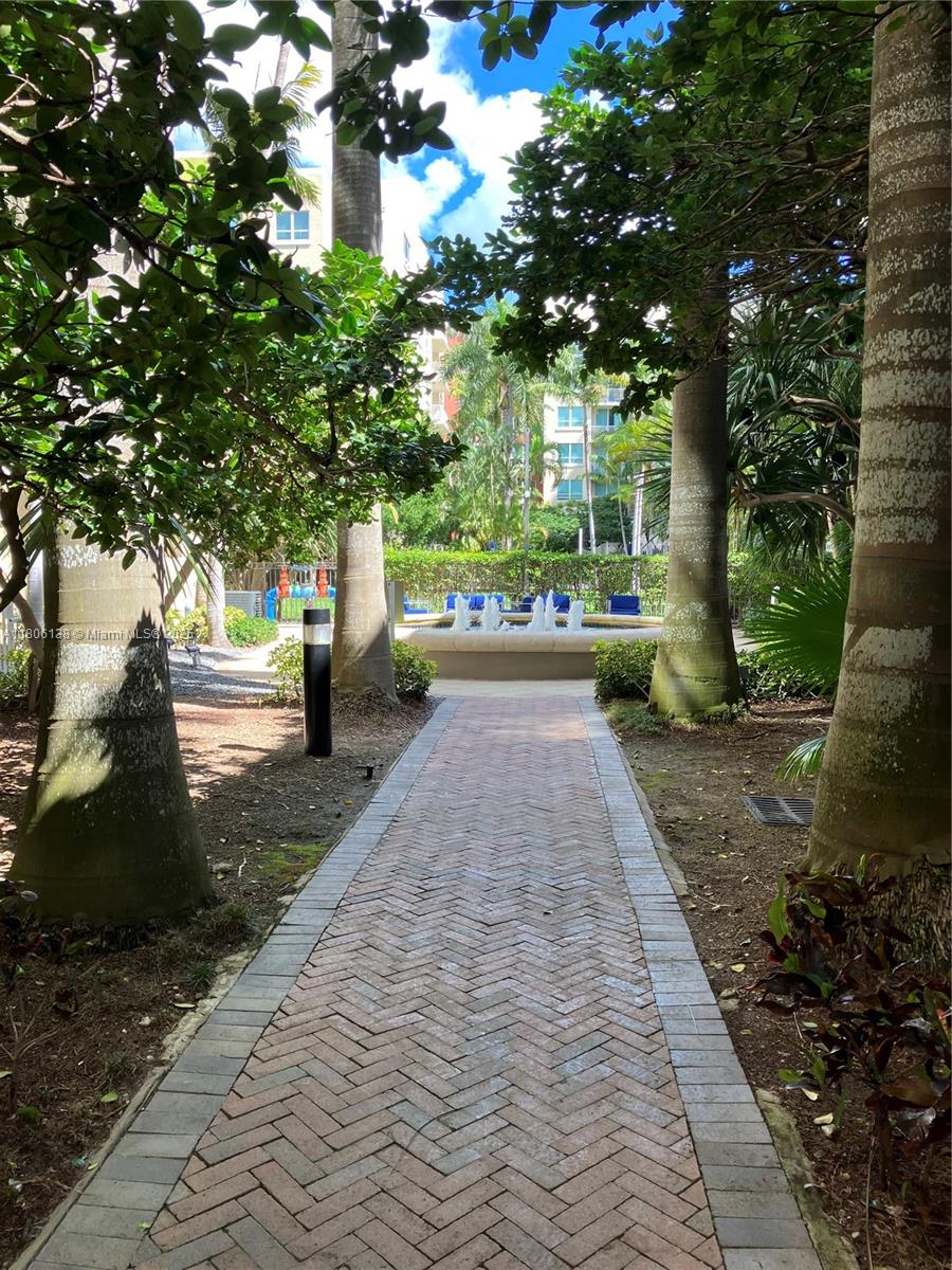 A brick walkway leads toward a fountain surrounded by trees and residential buildings — 2001 Biscayne Blvd # 3503, Miami FL 33137, MIAMI, FL