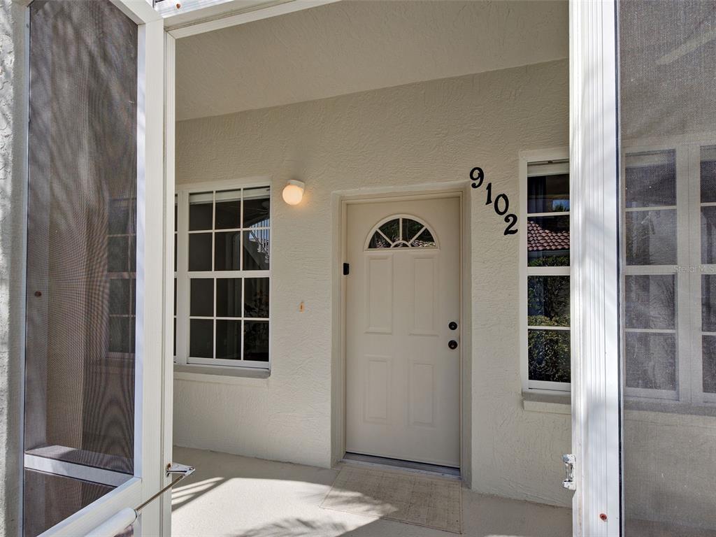 A front entrance features a white door with a window, house numbers, and a screen door — 9102 L PAVIA BOULEVARD UNIT 9102, VENICE, FL