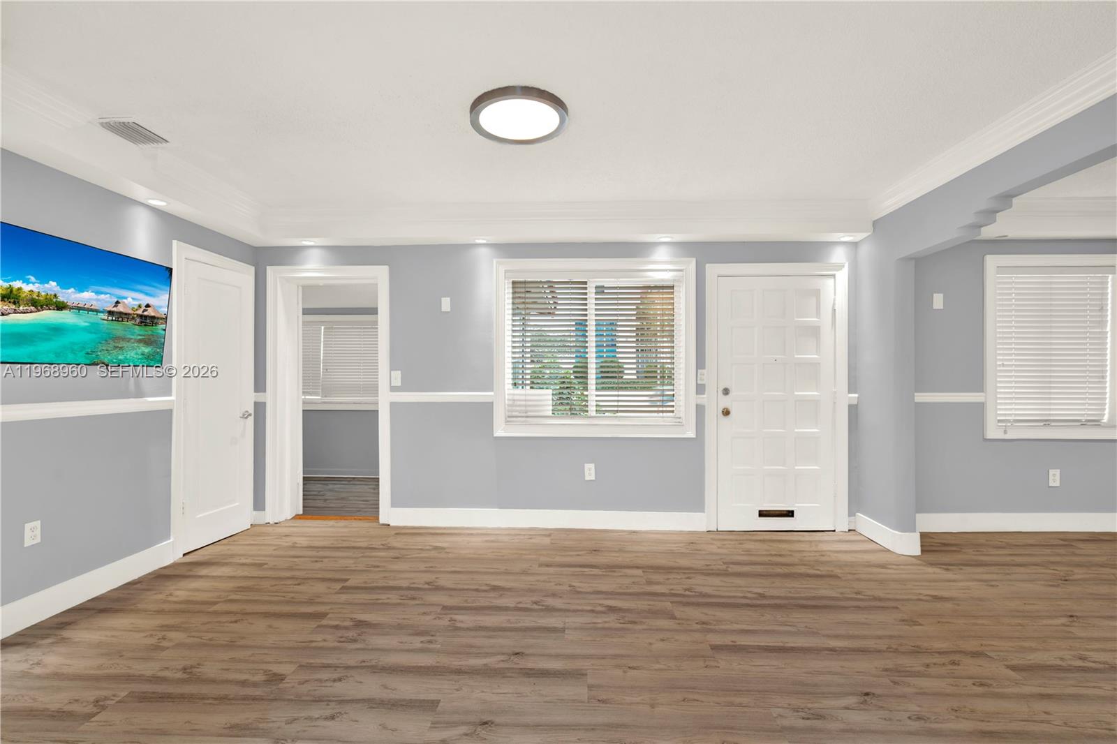 A living room features light gray walls, white trim, wood-look flooring, and a white front door — 2001 SW 37th Ave, Miami FL 33145, MIAMI, FL
