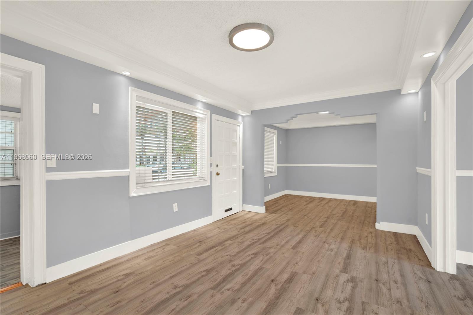 An empty room with light gray walls, white trim, and wood-look flooring — 2001 SW 37th Ave, Miami FL 33145, MIAMI, FL