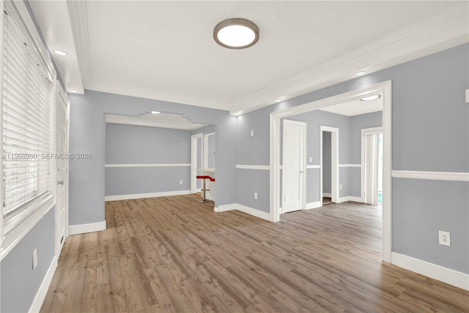 An interior view of a room with light gray walls, white trim, and wood-look flooring — 2001 SW 37th Ave, Miami FL 33145, MIAMI, FL