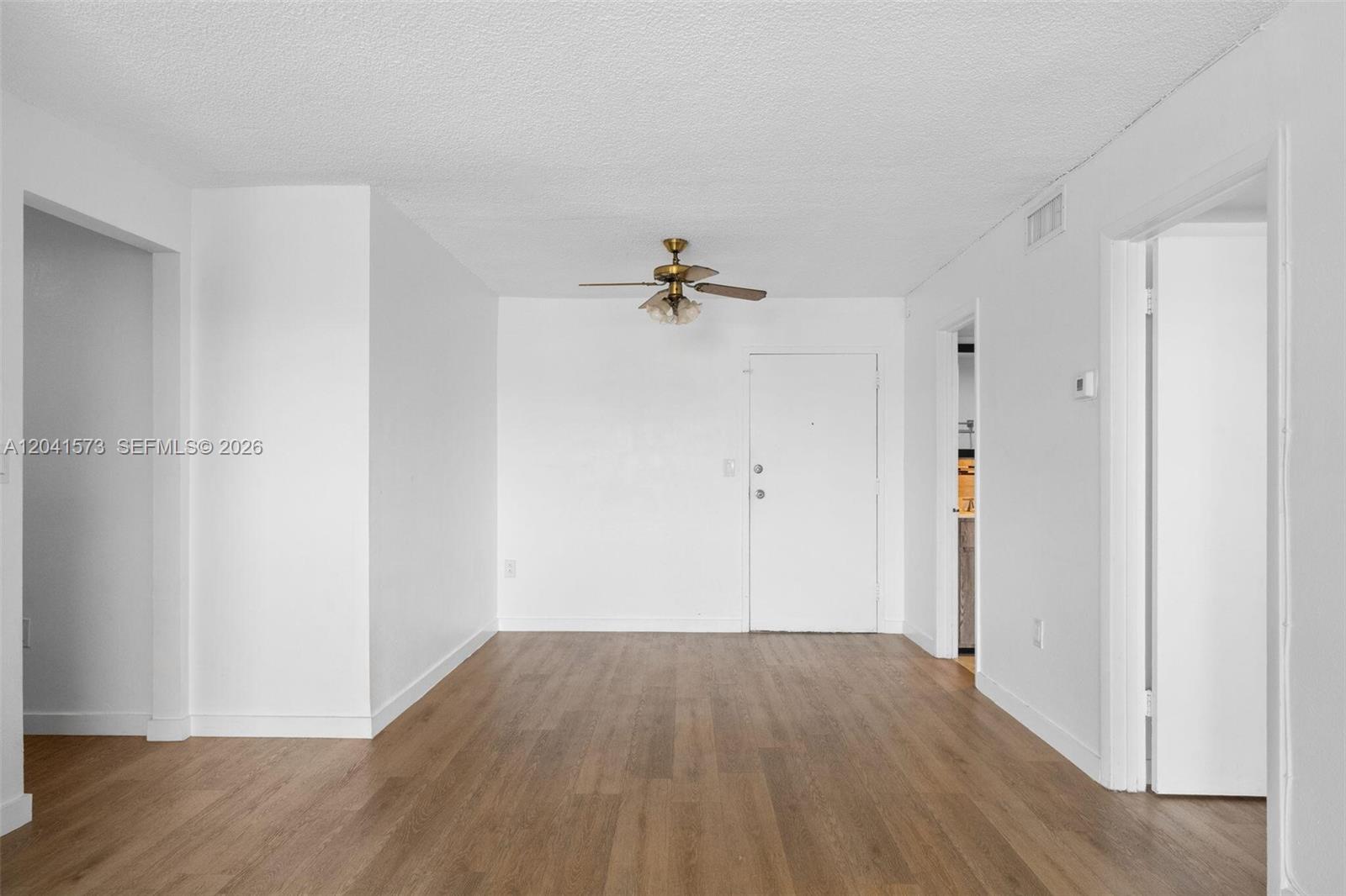 An empty room features white walls, wood-look flooring, and a ceiling fan — 4801 NW 7th St # 16, Miami FL 33126, MIAMI, FL