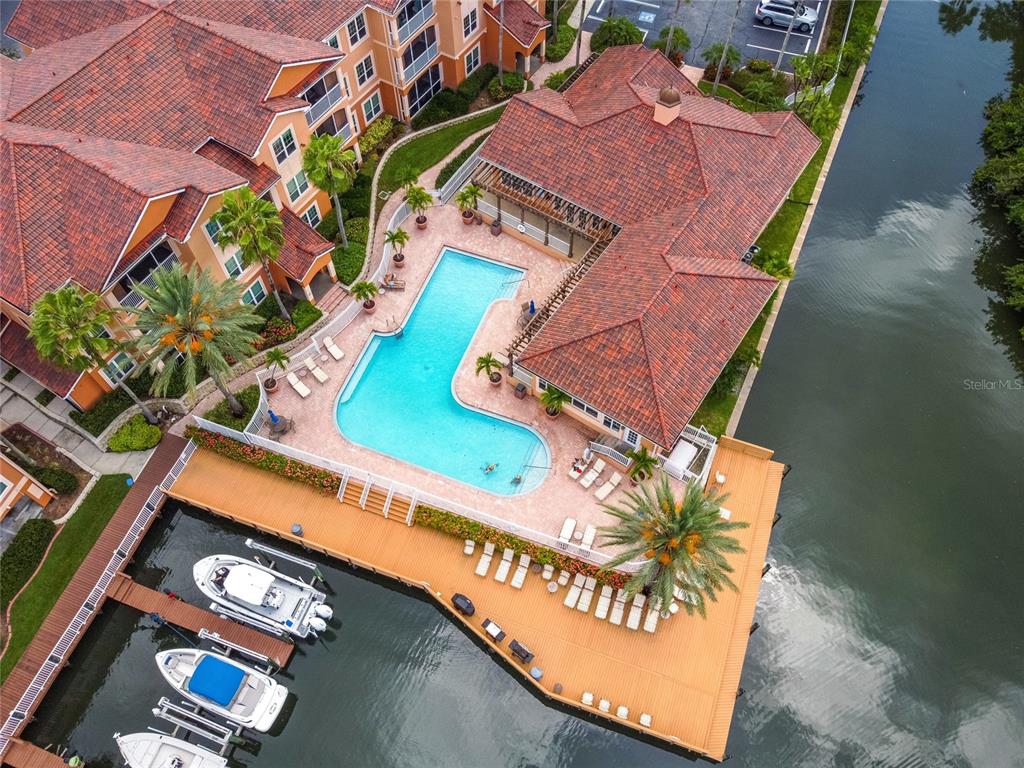 An aerial view shows a swimming pool, a wooden deck with boats, and a building — 5000 CULBREATH KEY WAY UNIT 1-312, TAMPA, FL