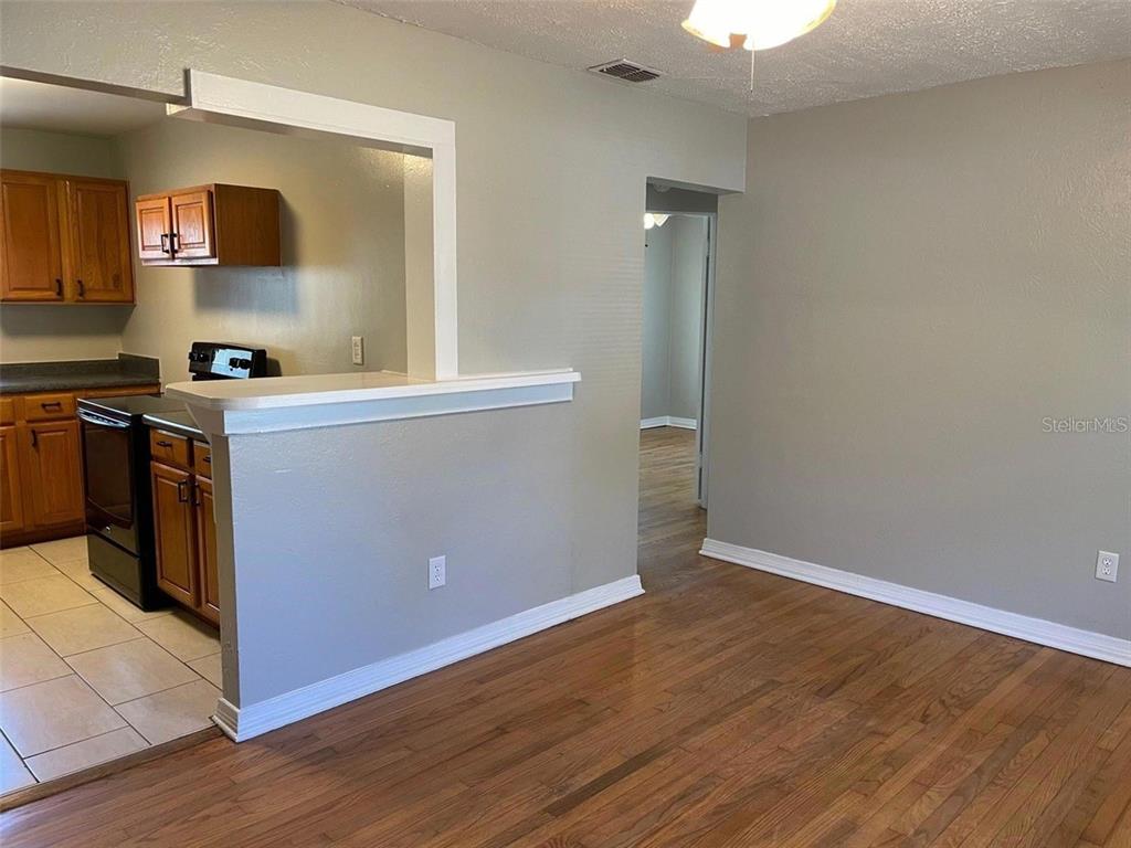 A view of a kitchen with wood cabinets and a dining area with hardwood floors — 320 W GRAVES AVENUE, ORANGE CITY, FL