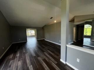 An open-concept living area features dark wood-look flooring, gray walls, and vaulted ceilings — 108 Greentree Lane, FL 34797, FL
