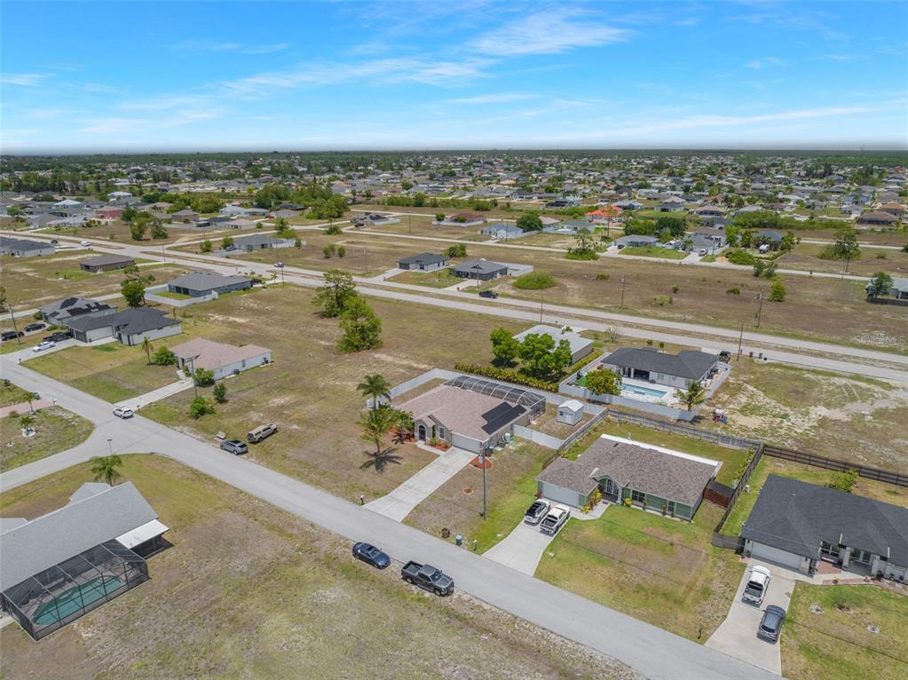 An aerial view shows several single-family homes with driveways and pools in a suburban neighborhood — 1709 NW 15TH TERRACE, CAPE CORAL, FL