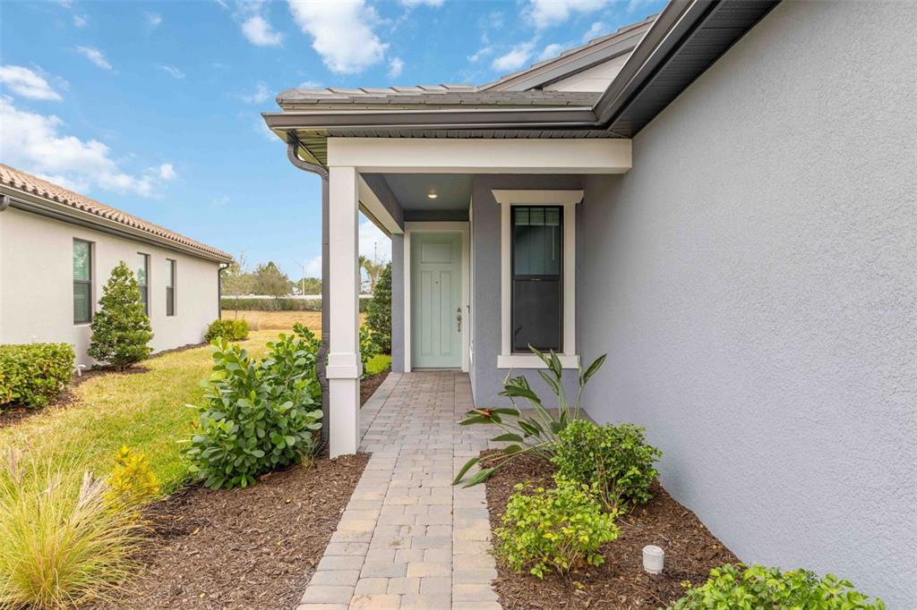 An open-concept living room and kitchen with light tile floors and white cabinetry — 5811 SILVERSIDE PINE COURT, LAKEWOOD RANCH, FL