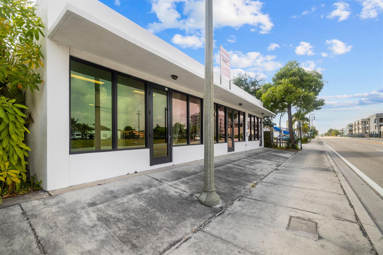 A white commercial building with large glass windows and a sidewalk along a road — 1808/1810 N Dixie Highway, FL 33460, FL