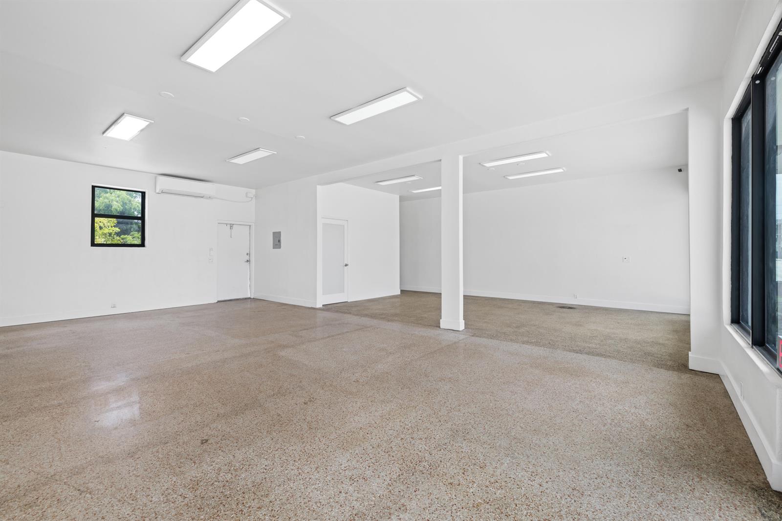 An empty commercial space features white walls, a polished concrete floor, and recessed ceiling lights — 1808/1810 N Dixie Highway, FL 33460, FL