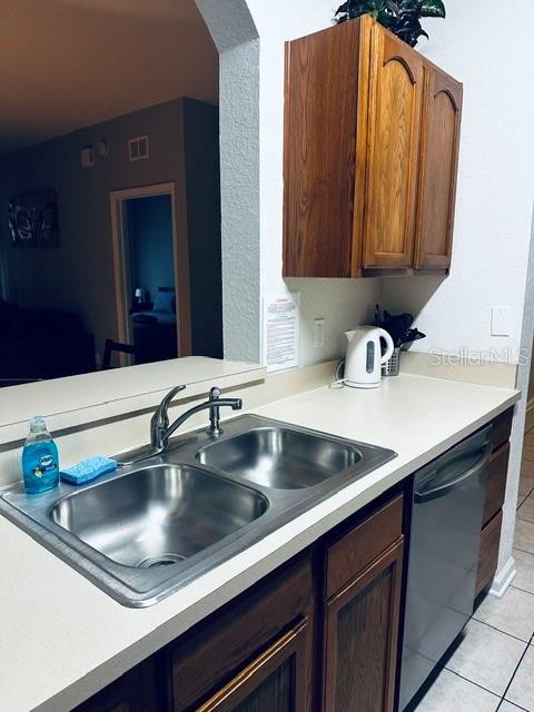 A kitchen sink with a faucet and a dishwasher is set into a white countertop — 2785 ALMATON LOOP UNIT 103, KISSIMMEE, FL