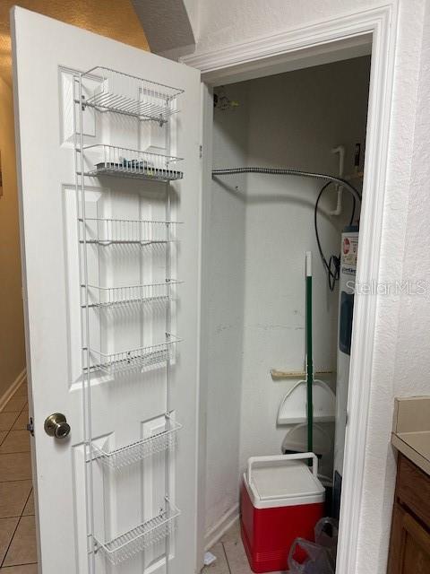 A utility closet features a white door with a wire storage rack and a water heater — 2785 ALMATON LOOP UNIT 103, KISSIMMEE, FL