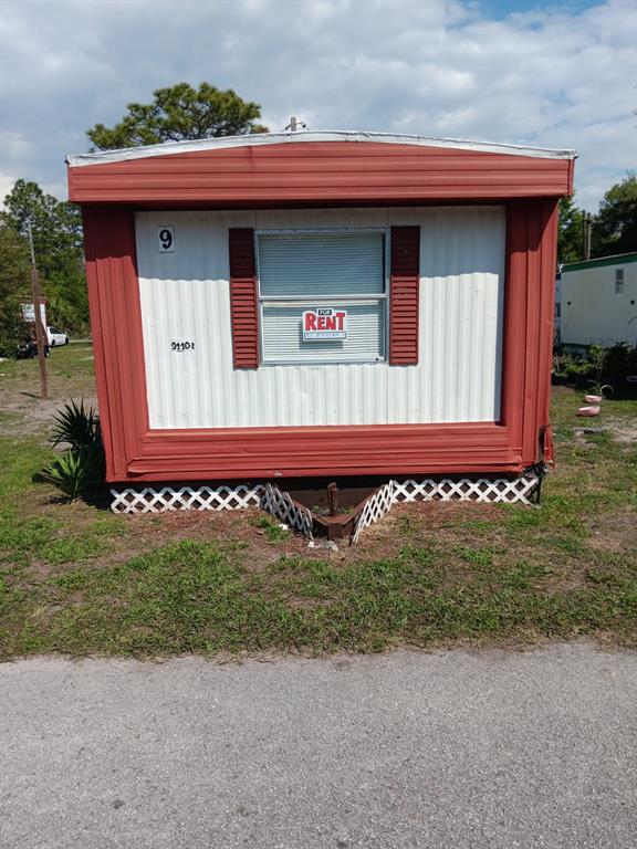 A red and white mobile home with a for rent sign in the window — 9440 BOURBON STREET UNIT 9, NEW PORT RICHEY, FL