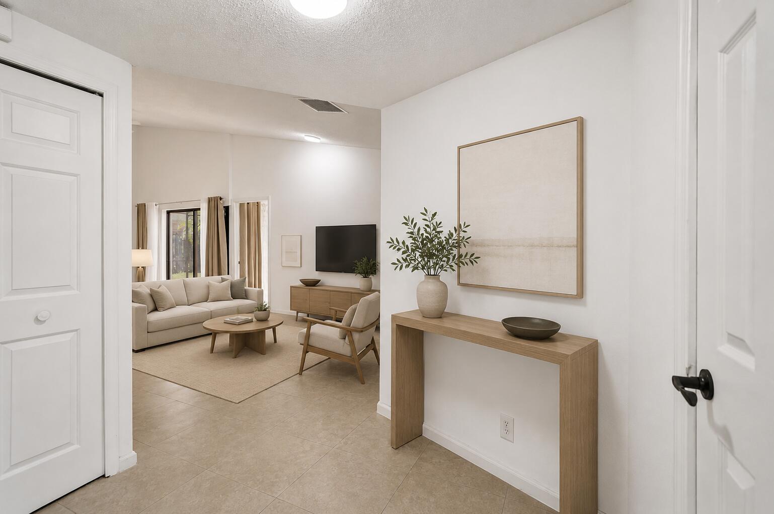 A bright entryway features a wooden console table leading into a living room with furniture — 820 NW 21st Way # 820, Delray Beach FL 33445, DELRAY BEACH, FL