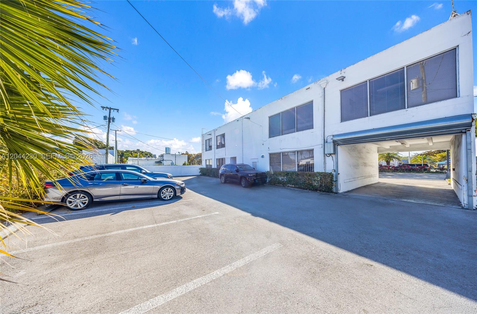 A two-story white commercial building features a parking lot with several parked cars — 1235 SW 22nd St, Miami FL 33145, MIAMI, FL