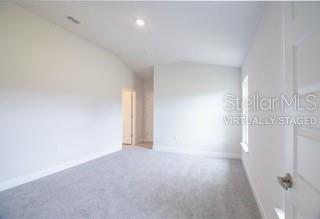 An empty bedroom with white walls, gray carpeting, and a vaulted ceiling — 1827 N ROBERTS TRAIL, BELL, FL
