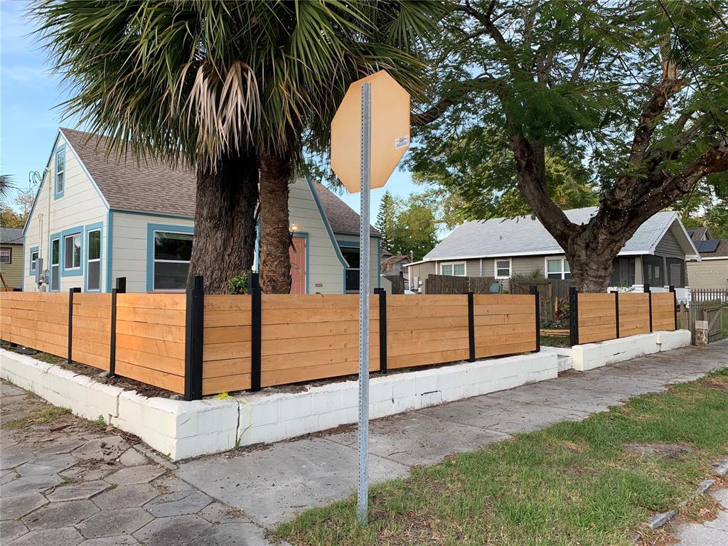 A house with a horizontal wood fence and a palm tree behind a stop sign — 1147 JAMES AVENUE S, ST PETERSBURG, FL