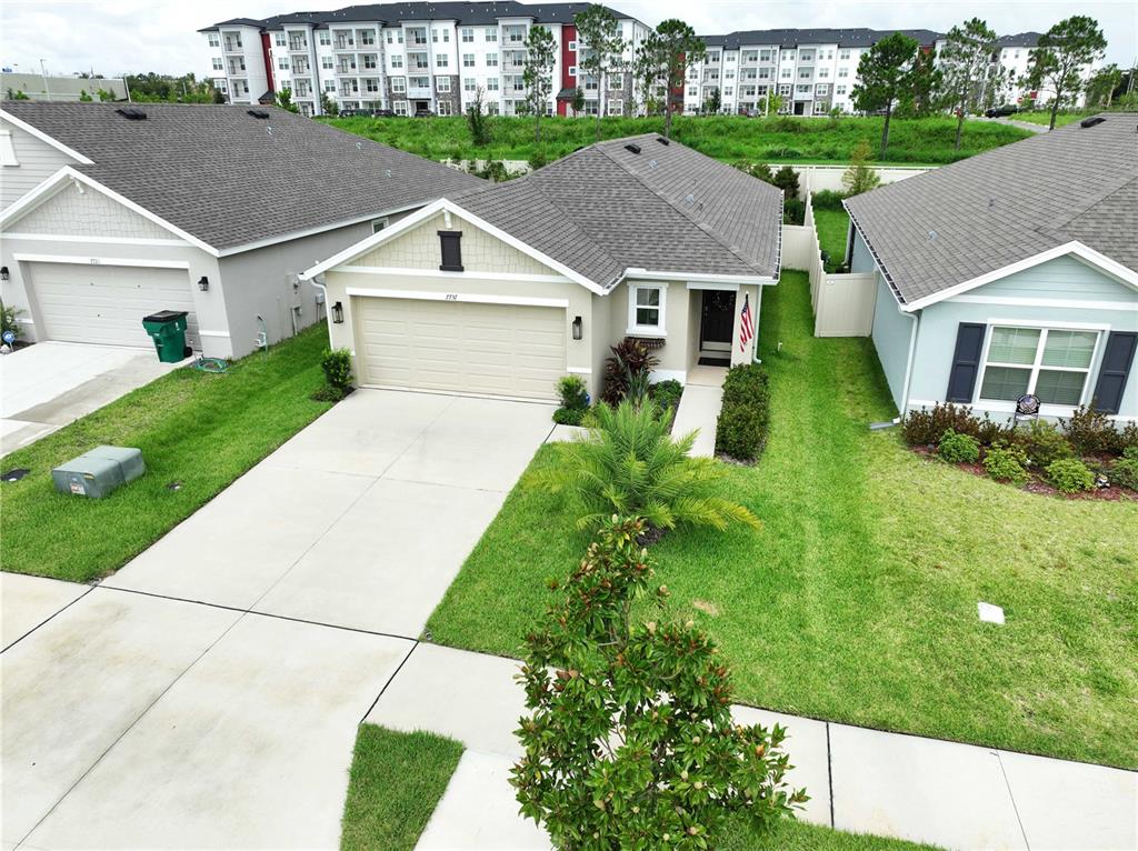 An aerial view shows a single-story house with a beige exterior, garage, and front lawn — 7737 SAIL CLOVER LANE, ZEPHYRHILLS, FL