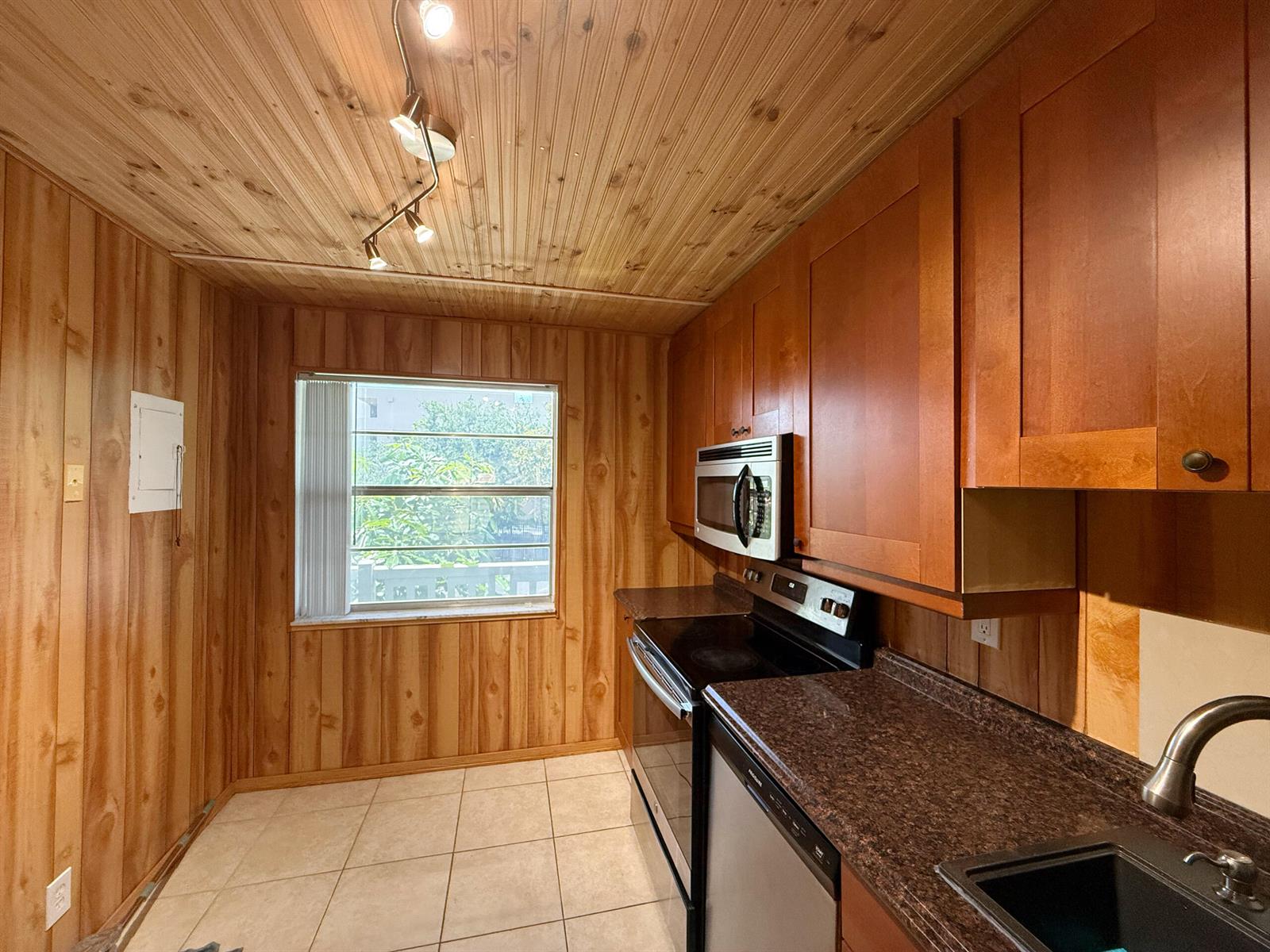 A kitchen with wood-paneled walls and ceiling, brown countertops, and stainless steel appliances — 3776 Inverrary Boulevard # 204r, Lauderhill FL 33319, LAUDERHILL, FL