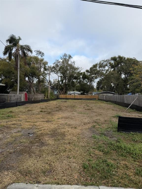 A vacant, rectangular residential lot is enclosed by wooden and black silt fencing — 1006 JONES STREET, CLEARWATER, FL