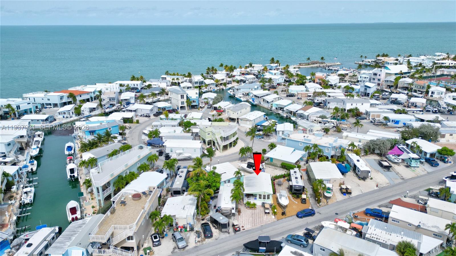 An aerial view shows a light-colored house with a red arrow pointing to its roof — 65821 Overseas Highway # 98, Long Key FL 33001, LONG KEY, FL