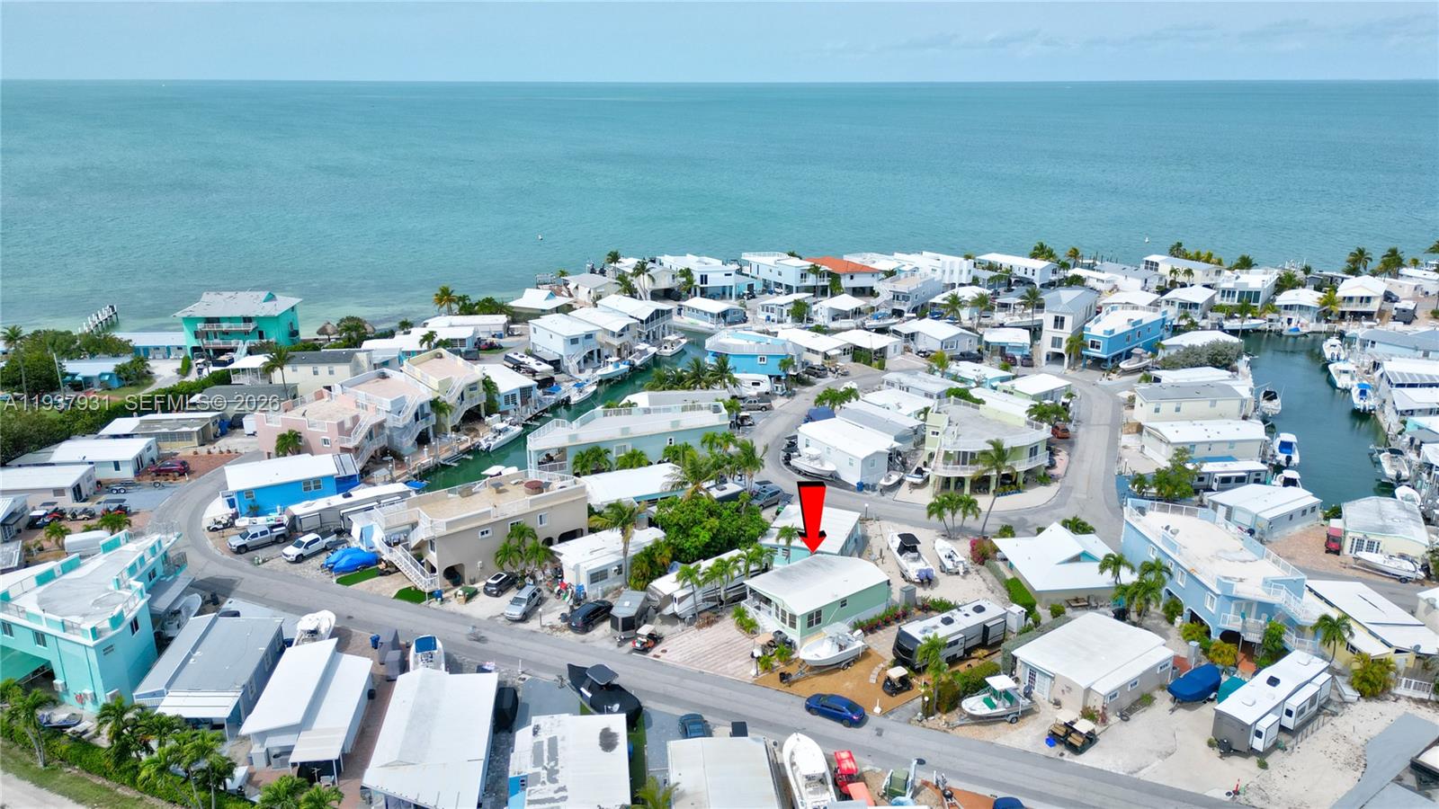 An aerial view shows a light green house with a red arrow pointing toward its roof — 65821 Overseas Highway # 98, Long Key FL 33001, LONG KEY, FL