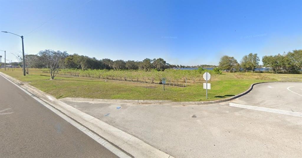 A vacant grassy lot sits next to a paved road and a parking area — 0 S HAVENDALE BOULEVARD NW, WINTER HAVEN, FL