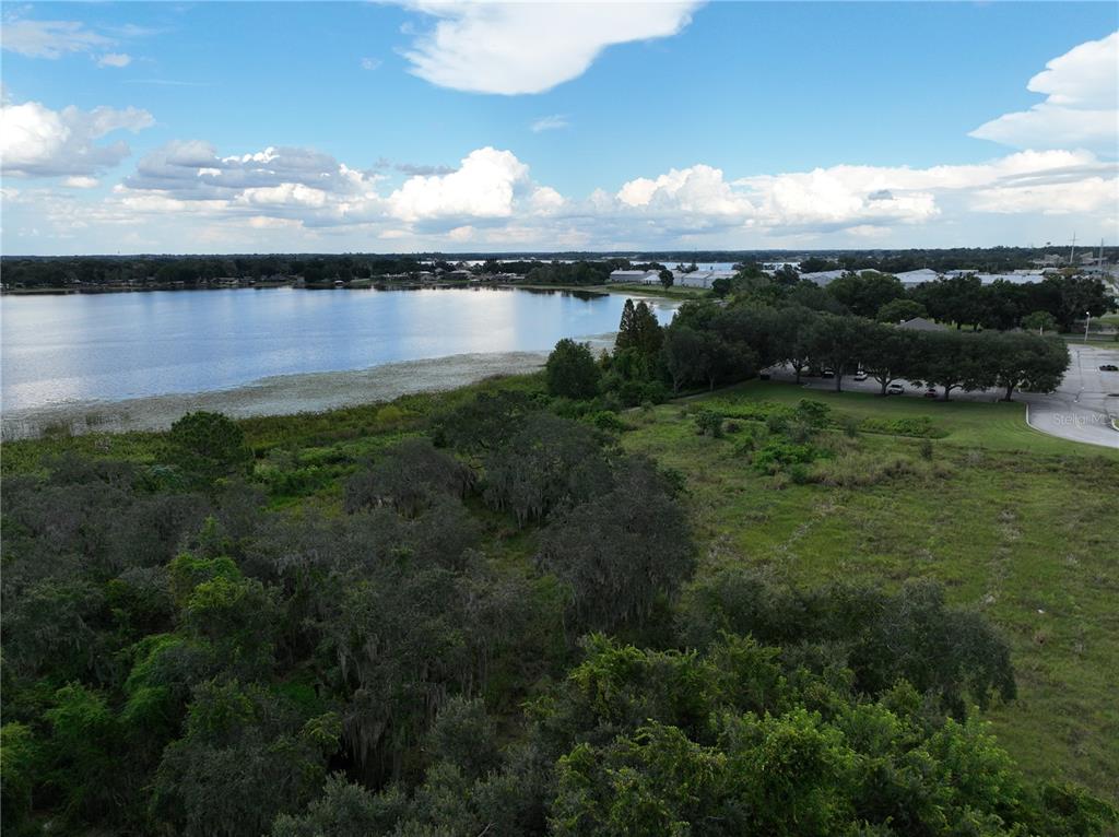 An aerial view shows a grassy field, a line of trees, and a large lake — 0 S HAVENDALE BOULEVARD NW, WINTER HAVEN, FL