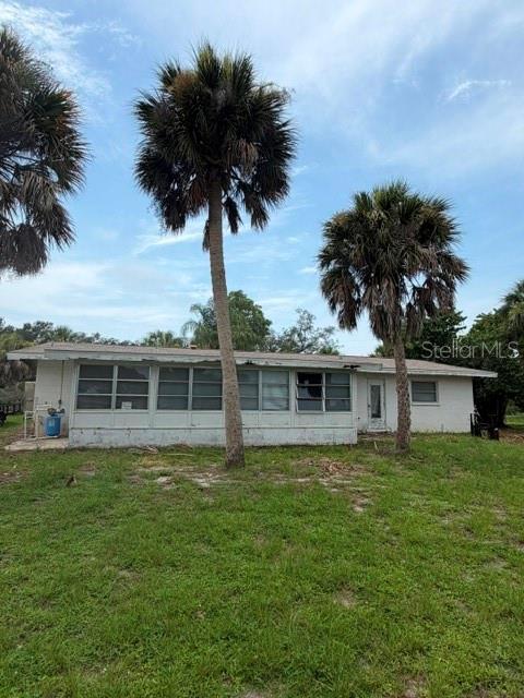 A single-story house with a white exterior and a screened-in porch under a cloudy sky — 1604 BAYSHORE ROAD, NOKOMIS, FL