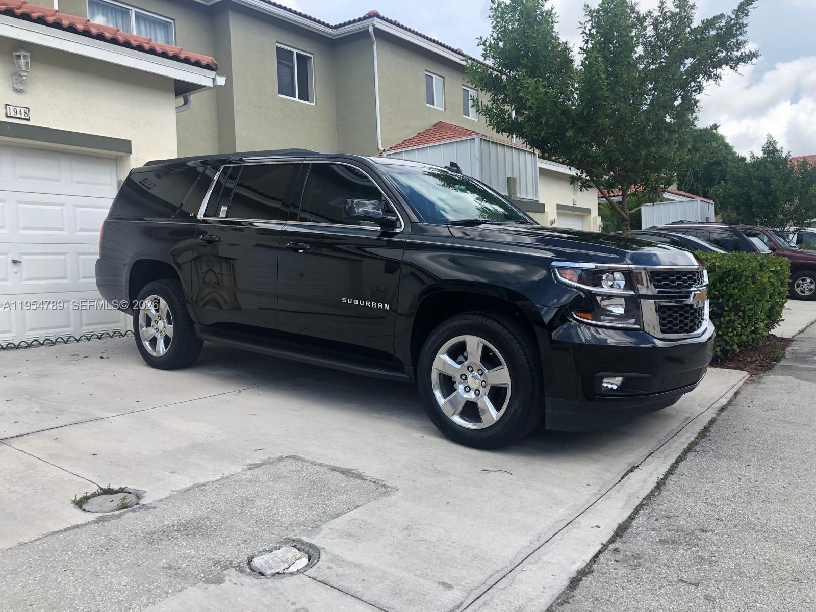 A black Chevrolet Suburban is parked in the driveway of a two-story residential building — 1948 SE 24th Ave, Homestead FL 33035, HOMESTEAD, FL