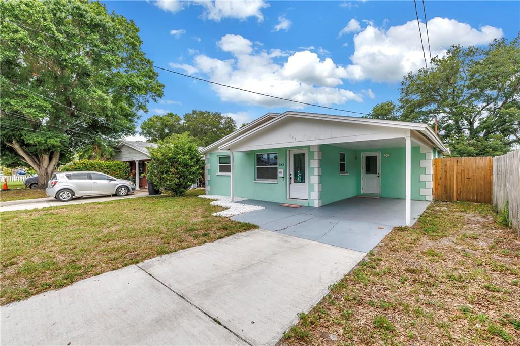 A light green single-story house with a front carport and a concrete driveway — 543 72ND AVE N, ST PETERSBURG, FL