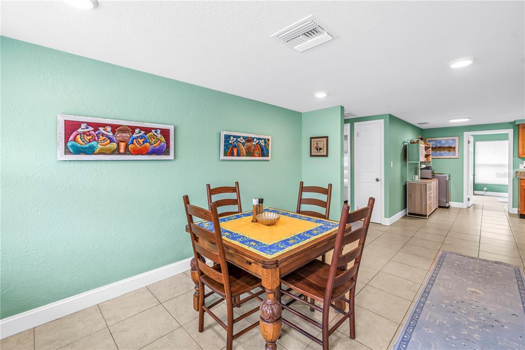 A dining area features a wooden table, four chairs, and artwork on a green wall — 543 72ND AVE N, ST PETERSBURG, FL